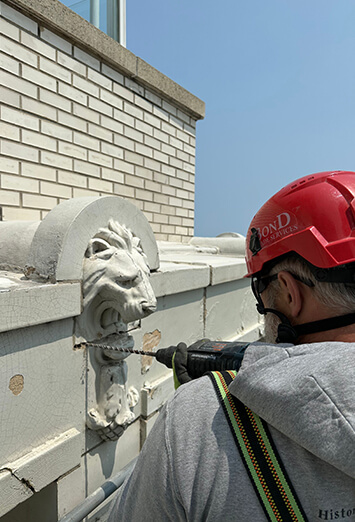 Building restoration employee inspecting slab of Milwaukee commercial building